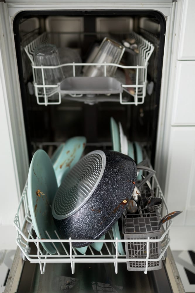 Dishwasher loaded with dirty dishes and cookware